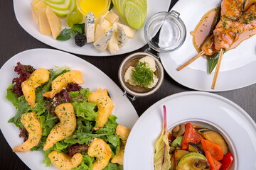 Delectable dishes for a feast, sturgeon kebab, cheese selection, crispy tempura shrimp, marinated veggies with mushrooms