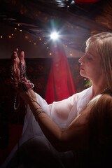 Beautiful arabian girl with candles in red room full of rich fabrics and carpets in sultan harem....