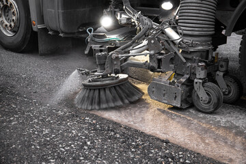 Close up view of heavy duty street cleaning vacuum machine known as street sweeper brushing the...