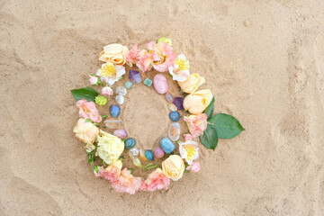 frame made of different minerals and flowers on sand natural background. Handmade floral...