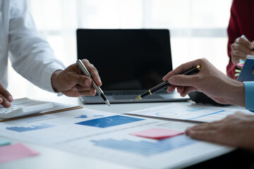 Teamwork of businessmen, investors discussing and calculating on financial data. Analyze business growth and point out chart statistics. Ready to record the information in the book.