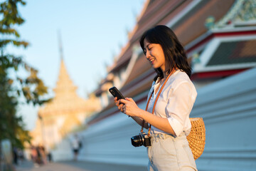 Portrait beautiful young asian woman with smart mobile phone around outdoor street view in a summer day