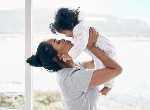 Mom Will Only Lift Me Higher. A Mother Holding Her Baby Daughter At Home.