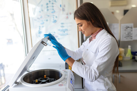 Scientist, worker, Laboratory technician using centrifuge device automation machine for testing and diagnostic clinical specimens sample in lab room of hospital. Medical science technology concept.