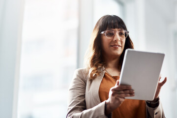 Shell always get the job done. an attractive young businesswoman using a digital tablet in her office.
