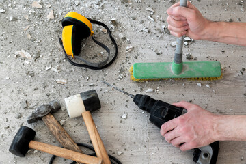 Concept of noisy and dirty work. Pieces of old plaster on the floor. Break and drill concrete...