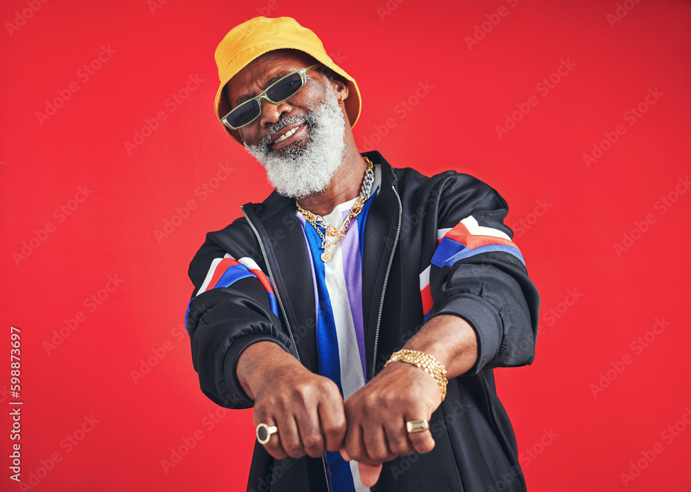 Poster hes everyones friend. studio shot of a senior man wearing retro attire while posing against a red ba