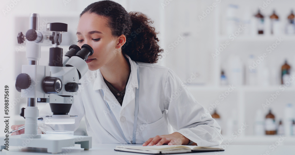 Wall mural another day of making new discoveries. a young scientist using a microscope in a lab.