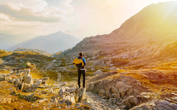 Hiker walks with backpack in sunset mountains. Lifestyle vacation hiking outdoor. Discovery Travel Destination Concept