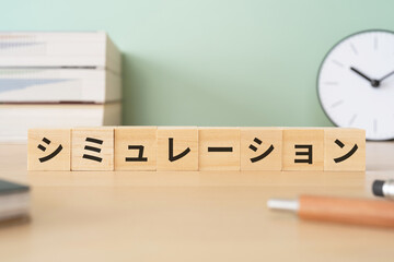 シミュレーションと書かれたブロックが置かれたデスク