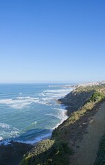 Wonderful landscapes in Portugal. Scenic coastline in Eirceira. View from the cliff. Wavy sea. Rocky skerries. Sunny spring day. Selective focus