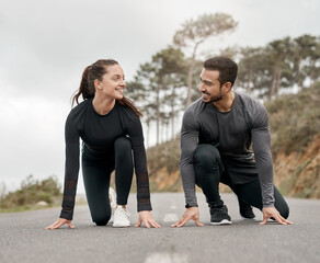 Lets race. Full length shot of two young athletes crouched down in a starters position before exercising outside.