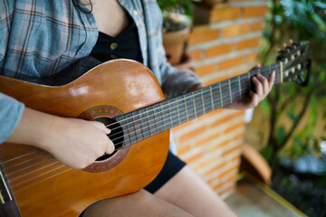 Obraz premium Happy young Woman hands playing acoustic guitar musician &nbsp;alone compose instrumental song&nbsp;lesson on playing the guitar