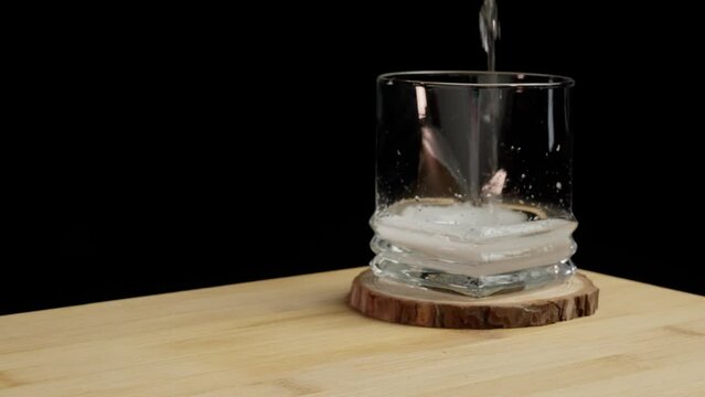 stirring sparkling  drink in empty glass - black background (4k - slow motion)[ high quality colors]