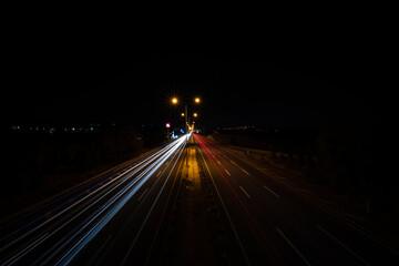 Fototapeta na wymiar Flowing traffic and lengthening lights of vehicles on the highway at night. Long exposure 
