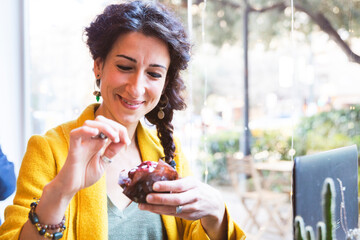 Smiling woman holding a chocolate cupcake