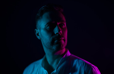 Portrait of a handsome unshaven middle-aged man. In neon light.