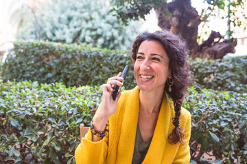 Smiling woman talking on the phone in a park