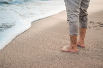 A Young Man Standing Right on The Beach Barefoot at Sunset in Yogyakarta Province