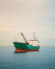 Cargo ship in the middle of the sea at the border between Indonesia and Singapore when sunset.