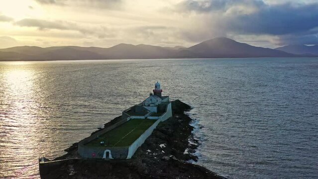 Aerial panorama view of the historic Fenit Lighthouse in Tralee Bay, beautiful clouds, sunset. High quality 4k footage Generative AI