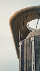 A tall building with round edge unique architecture lit up by the morning sun