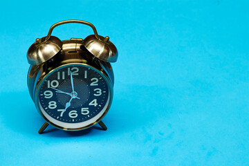 alarm o'clock showing 7 o'clock isolated on blue background