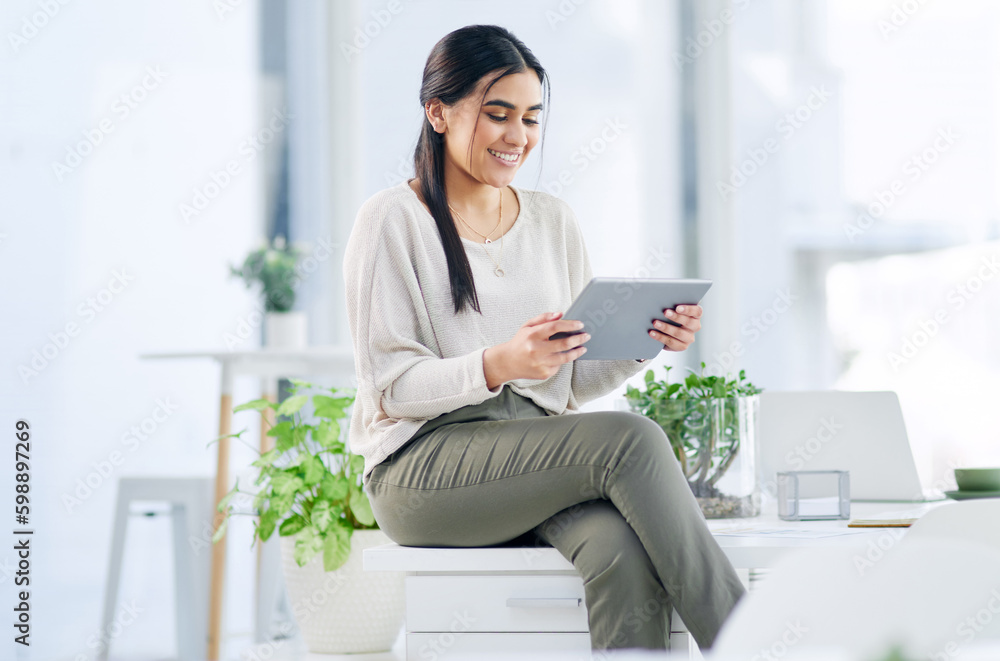 Wall mural Increasing productivity is always a win. a young businesswoman using a digital tablet in an office.