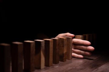 insurance with hands protect domino. Businessman hands stop dominoes falling in business crisis. business risk control and planning and strategies to run prevent insurance businesses.