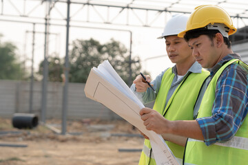 Engineers use blueprint check construction on site. Contractor and inspector inspection...