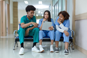 Group of medical student sitting front classroom using tablet searching information study and...