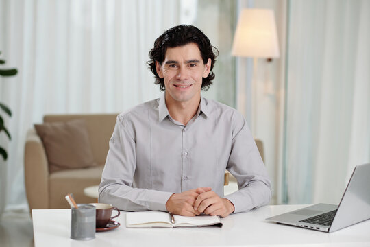 Smiling entrepreneur working at desk in his home office