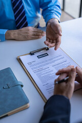 Job seekers and interviewers close up front at the conference room in the office. New graduates fill in their resume details personally in preparation for a job application at the HR department.