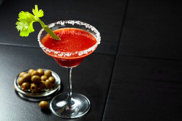 Bloody Mary cocktail with celery and green olives.