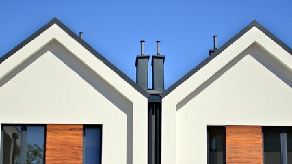 Terraced family homes in newly developed housing estate. The real estate market in the suburbs. New single family houses in a new development area. Residential homes with modern facade. 