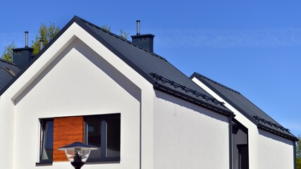 Terraced family homes in newly developed housing estate. The real estate market in the suburbs. New single family houses in a new development area. Residential homes with modern facade. 