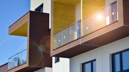 Fototapeta premium Modern apartment buildings on a sunny day with a blue sky. Facade of a modern apartment building. Contemporary residential building exterior in the daylight. 