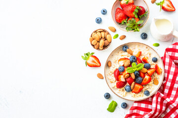 Oatmeal porrige with fresh berries and nuts. Healthy breakfast, top view.