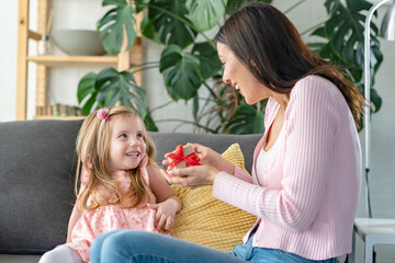 Smiling mother got a present from her cute little daughter