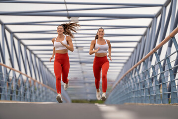 Athlete twin sisters doing continuous running inside a tunnel bridge