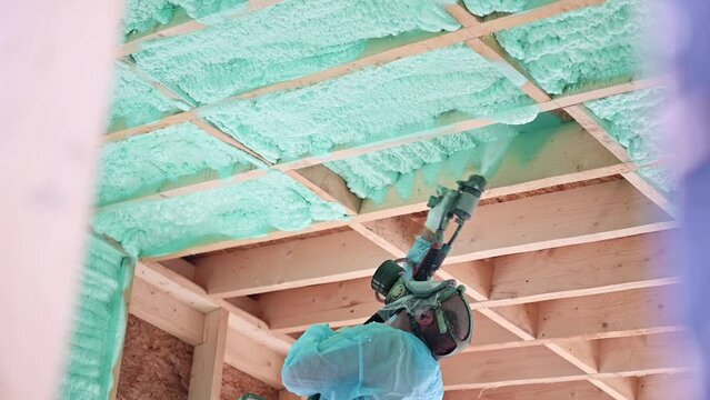 Male builder insulating wooden frame house. Man worker spraying polyurethane foam inside of future cottage, using plural component gun. Construction and insulation concept. Generative AI