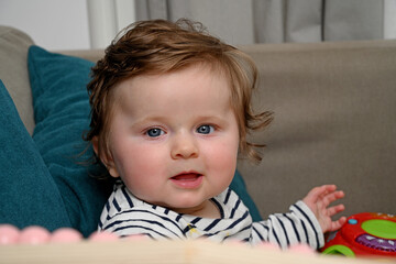 Naklejka premium smiling newborn baby sitting on sofa