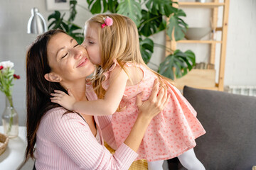 A daughter kisses her mother at home