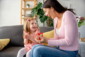 Smiling mother got a present from her cute little daughter