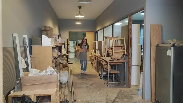 Artist's Studio: A young woman stands in an art studio filled with easels, canvases, and art supplies, illuminated by natural light.