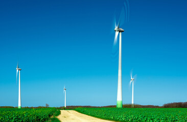 windmills spinning in the wind on a clear day - obrazy, fototapety, plakaty