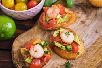 Homemade bruschetta with shrimps, avocado and cherry tomato