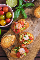 Homemade bruschetta with shrimps, avocado and cherry tomato - 598916873