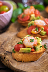 Homemade bruschetta with shrimps, avocado and cherry tomato - 598916886