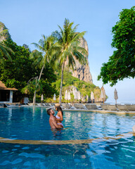 couple of men and women at a swimming pool of a luxury resort in Thailand